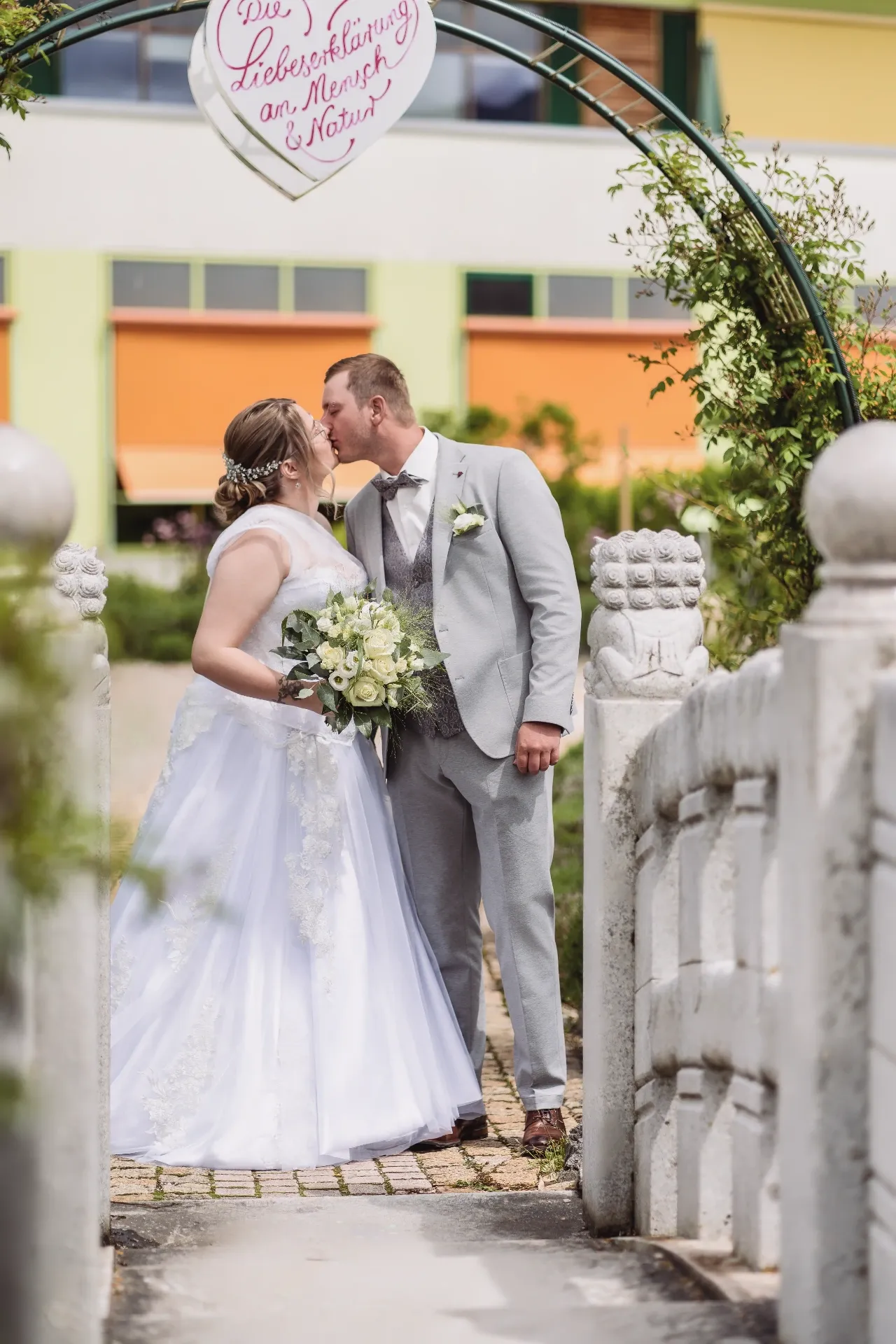 Romantischer Kuss unter Blütenbogen